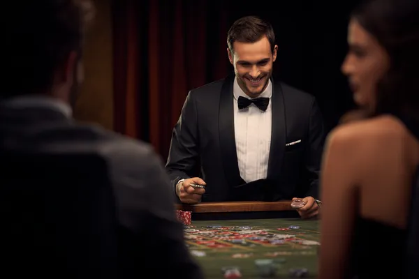 A woman in a luxurious green gown next to an ornate roulette wheel, capturing the upscale casino mood of 9SL.